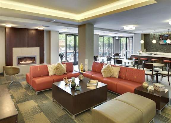 Be @ Axon Green Community Room with comfy chairs, couches, coffee table, and fire pit