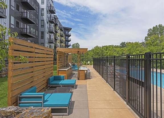 Be @ Axon Green Poolside Lounge Area with blue couches and grill area