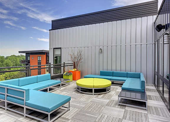 Be @ Axon Green Rooftop Patio lounge area with blue couches and green sofa table