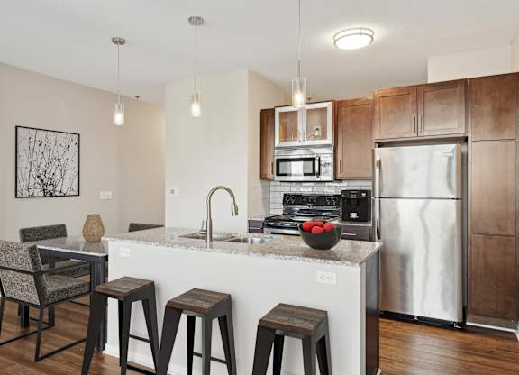A kitchen with a white countertop and a stainless steel refrigerator. at The Palmer, Minneapolis, MN