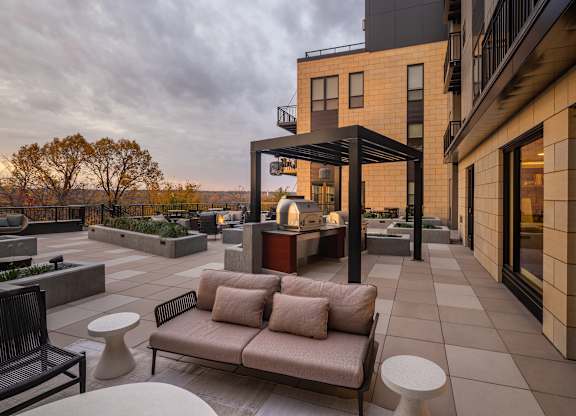 A patio with a couch and a table with a glass top.at Lilia, Lilydale, Minnesota