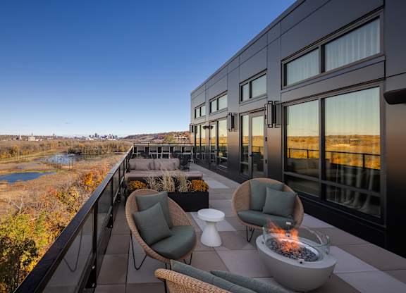 A modern balcony with a fire pit and comfortable seating.at Lilia, Lilydale, MN