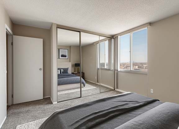 a bedroom with a bed and a large window at The Edina Towers, Edina, Minnesota