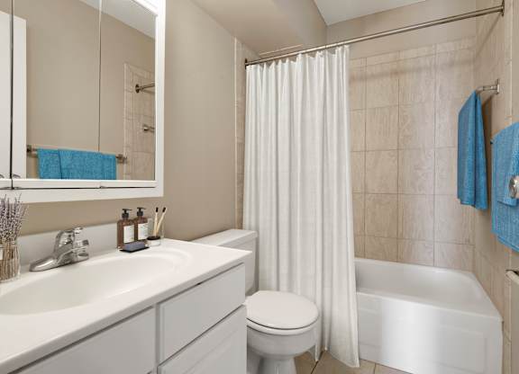 a bathroom with a white bathtub and a white toilet next to a white sink with a at The Edina Towers, Edina