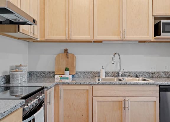 a kitchen with wooden cabinets and granite counter tops at Zelia on Seven, St Louis Park, 55416