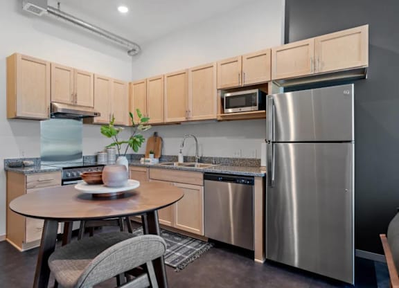 a kitchen with stainless steel appliances and a small table at Zelia on Seven, St Louis Park, Minnesota