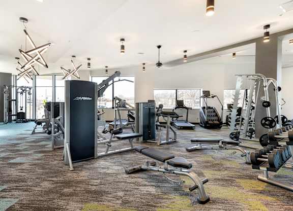 A gym with a variety of equipment including weights and cardio machines.