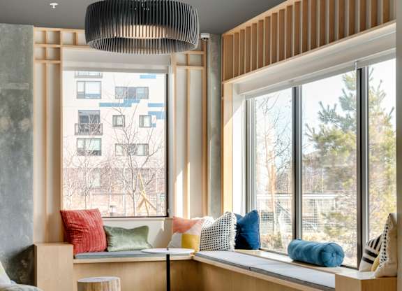 Sunny lobby with window seating and a black couch