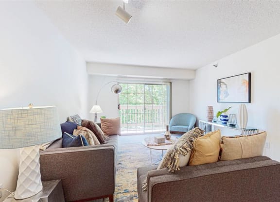 a living room with couches and chairs and a window