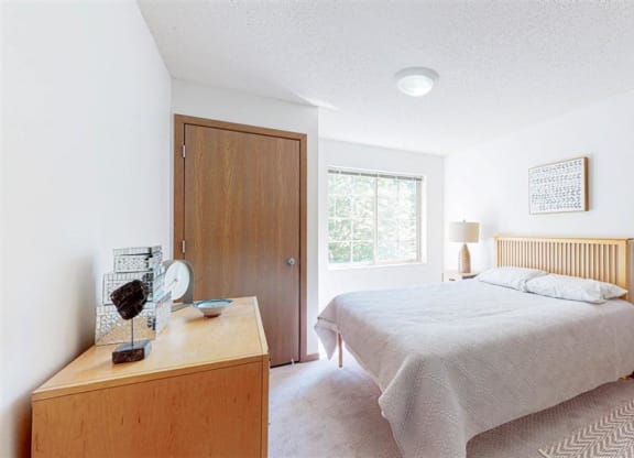 a bedroom with a bed and a dresser and a window