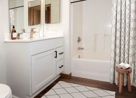 a white bathroom with a shower and a sink