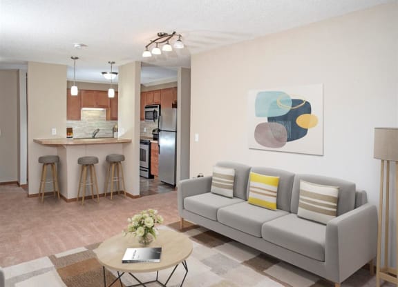 a living room and kitchen with a couch and a table