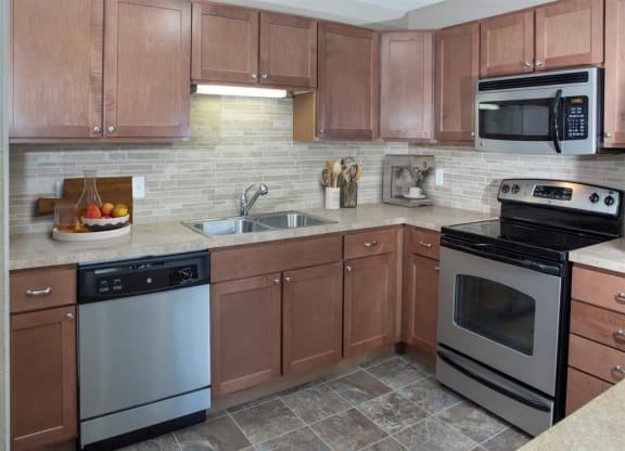 a kitchen with stainless steel appliances and wooden cabinets
