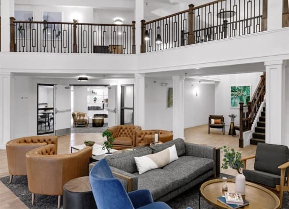 a shared common area with couches and chairs and a balcony
