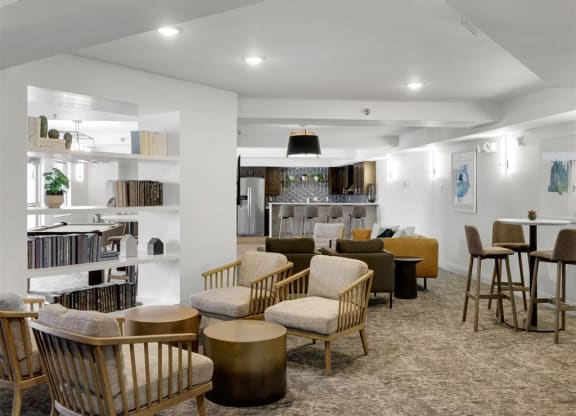 a living room with tables and chairs and a kitchen