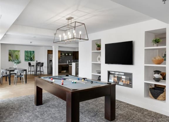 a pool table in a shared community room with a tv
