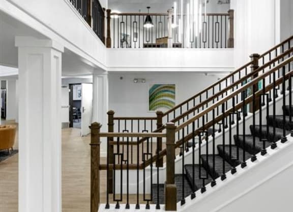 a sweeping staircase in a home with white walls and wood floors
