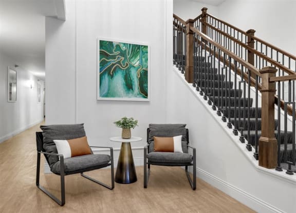 a living room with two chairs and a staircase
