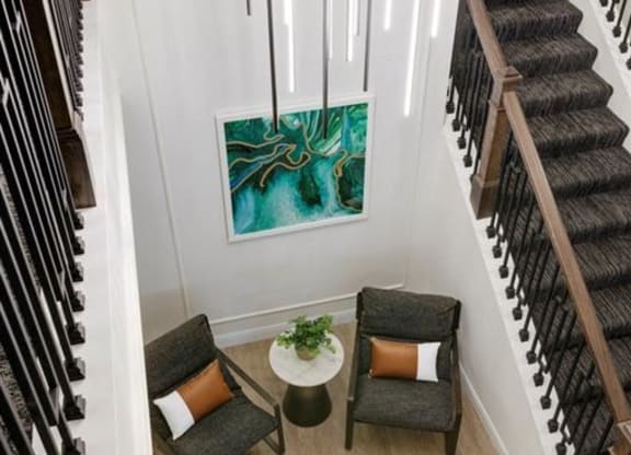 a view of a stairwell with two chairs and a table