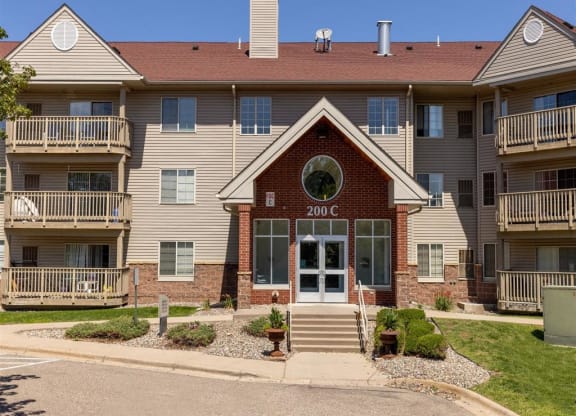 the front of an apartment building with stairs and a window
