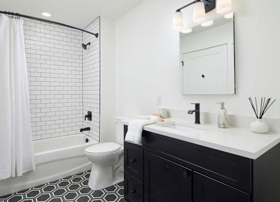 a black and white bathroom with a shower and a sink