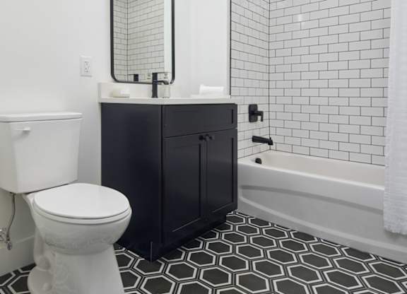 a black and white bathroom with a toilet and a shower