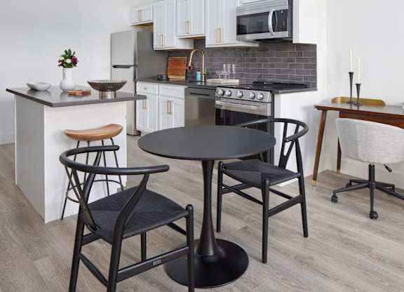 a kitchen and dining area with a table and chairs