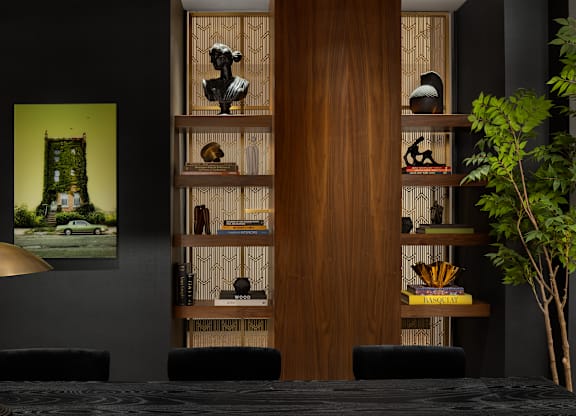 A room with a black table and a lamp with a gold shade.