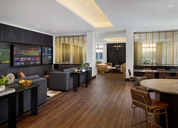 A modern living room with dark wood floors and a variety of seating options.