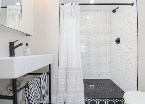 A white bathroom with a black and white checkered towel.
