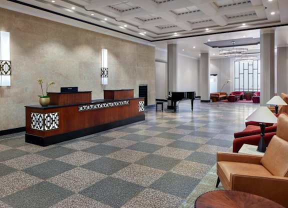 A reception area with a checkered floor and a brown sofa.