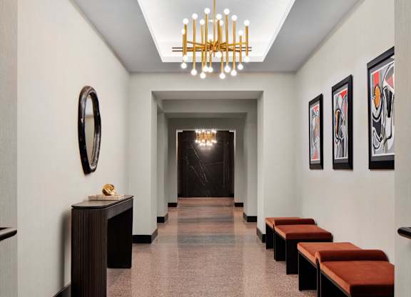 A hallway with a row of benches and pictures on the wall.