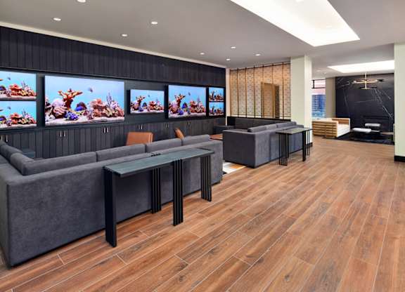 A modern living room with a grey sofa and a glass coffee table.