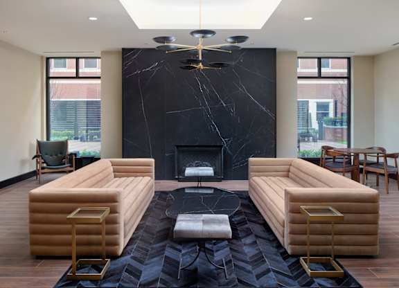 A living room with a fireplace and a black marble mantle.