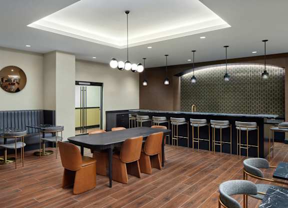 A modern dining room with a dark wood table and chairs.