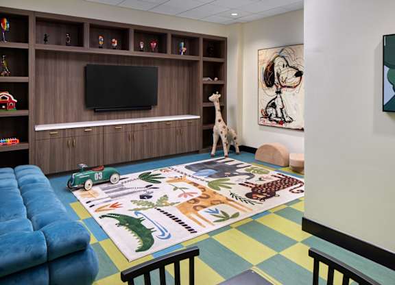 A room with a blue mat on the floor and a giraffe toy on it.