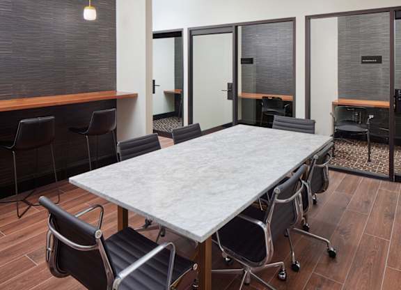 A conference room with a long table and chairs.