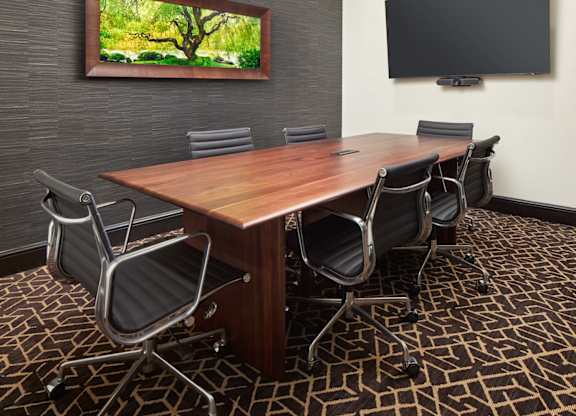 A conference room with a large table and chairs.