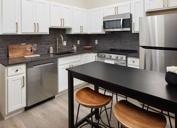 a kitchen with stainless steel appliances and a black counter top