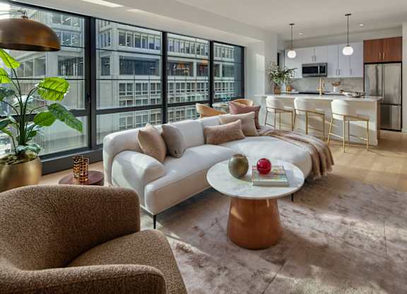 A modern living room with a large window overlooking a cityscape.at 17 Market West, Philadelphia, PA 19103