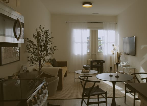 A living room with a couch, chairs, and a table.