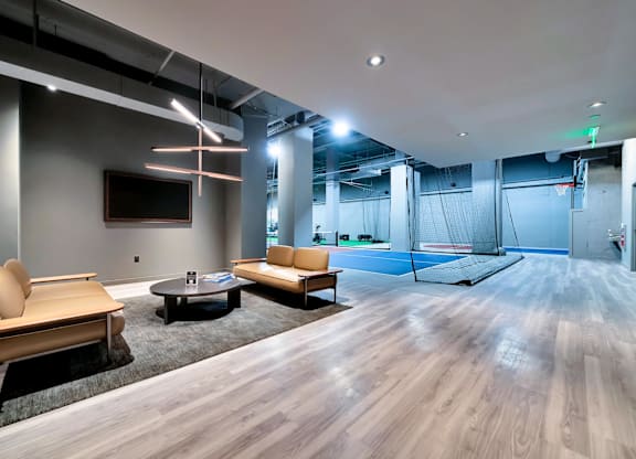 A modern living room with a wooden floor and a television on the wall.