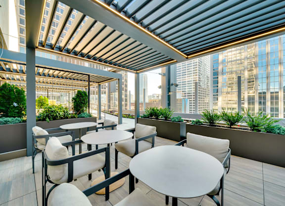 A patio with tables and chairs overlooking a cityscape. at 17 Market West, Philadelphia Pennsylvania