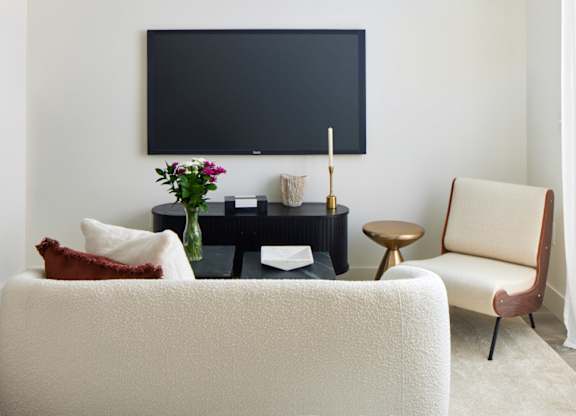 a living room with a white couch and a television
