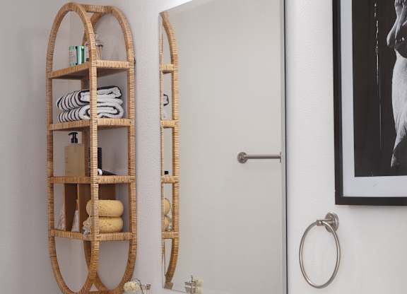 A bathroom with a white vanity and a round mirror at The PARKER on E Mulberry Apartments, Texas