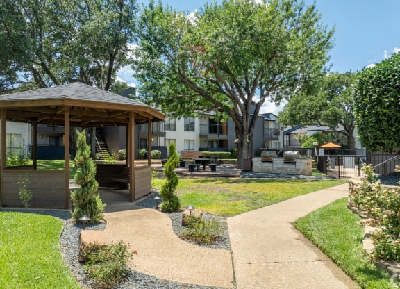 a gazebo in a park with trees and a building in the background at District 2308, Texas ?