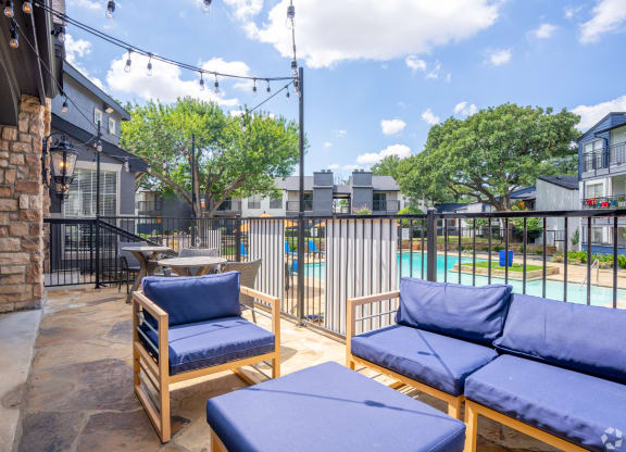 a patio with couches and chairs and a pool at District 2308, Texas, 76011