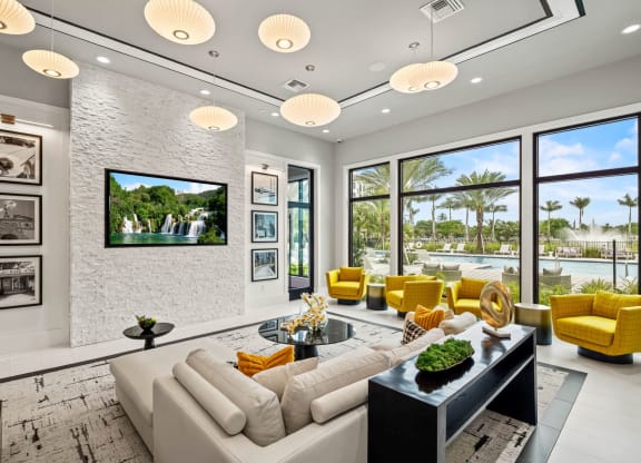 a living room with a white brick wall and yellow chairs and couches at Altis Grand Kendall, Florida