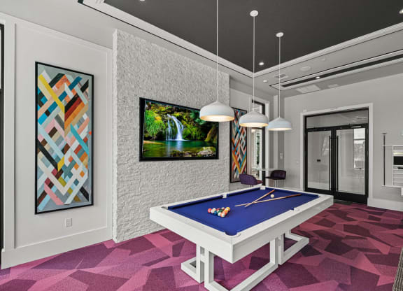 a game room with a blue pool table and a waterfall at Altis Grand Kendall, Florida
