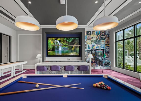 a billiards room with a blue pool table and a large window at Altis Grand Kendall, Miami Florida